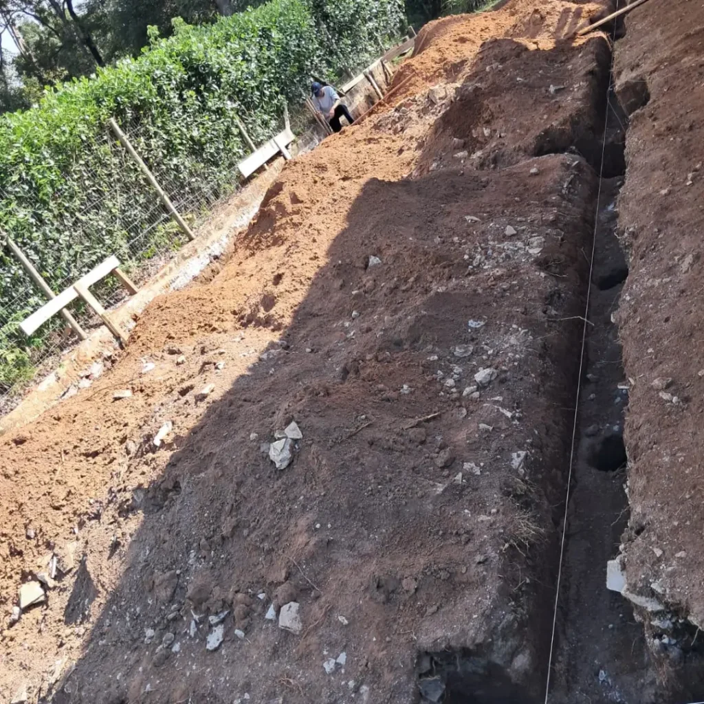 Detalhe técnico de escavação para sapata e pilares, evidenciando a montagem de alta precisão da caixaria estrutural.