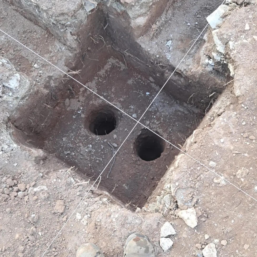Detalhe técnico de escavação para sapata e pilares, evidenciando a montagem de alta precisão da caixaria estrutural.